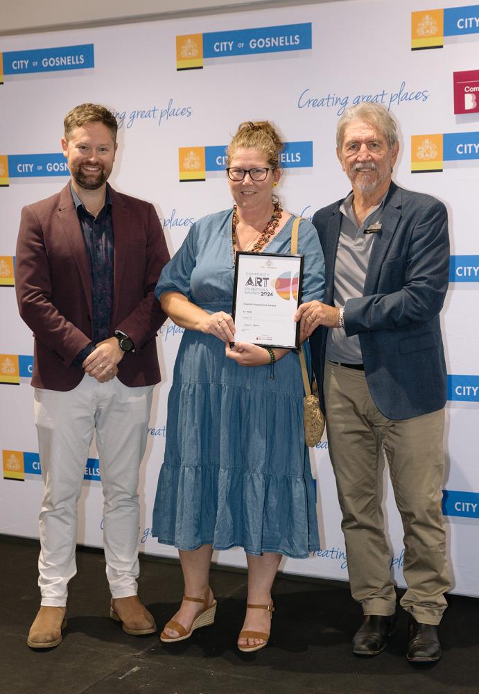 Caption – City of Gosnells Deputy Mayor Adam Hort with artist Eve Wolfe and Bendigo  Bank Canning Vale Chairperson Geoff Wolfenden. Eve’s artwork Forever 18 was awarded  the $5,000 Overall Acquisitive Prize at the City of Gosnells Community Art Exhibition and  Awards.