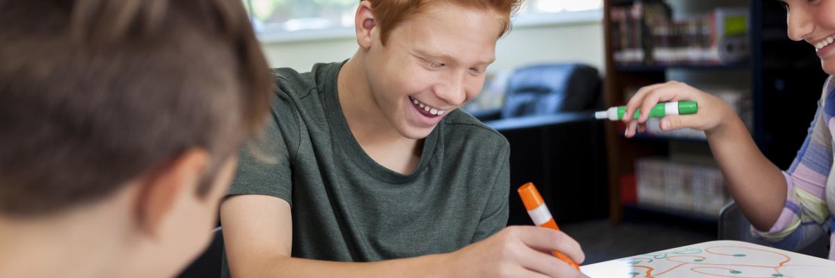 Teen drawing on whiteboard in library