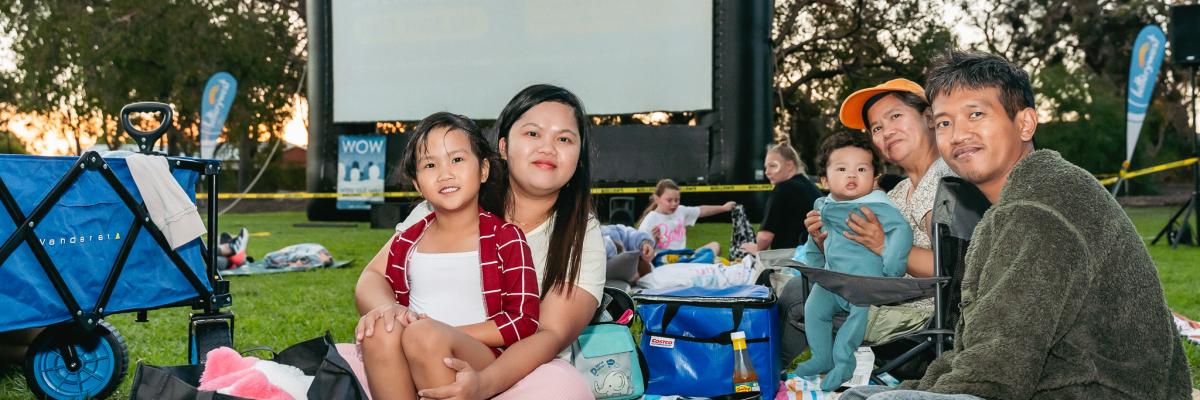 Image of family sitting in front of an outdoor screen