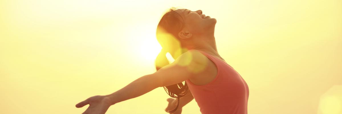 A woman standing in the sun, soaking up the light and warmth with pleasure