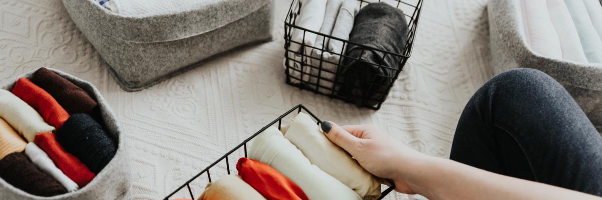 A variety of folded clothes neatly organised into containers