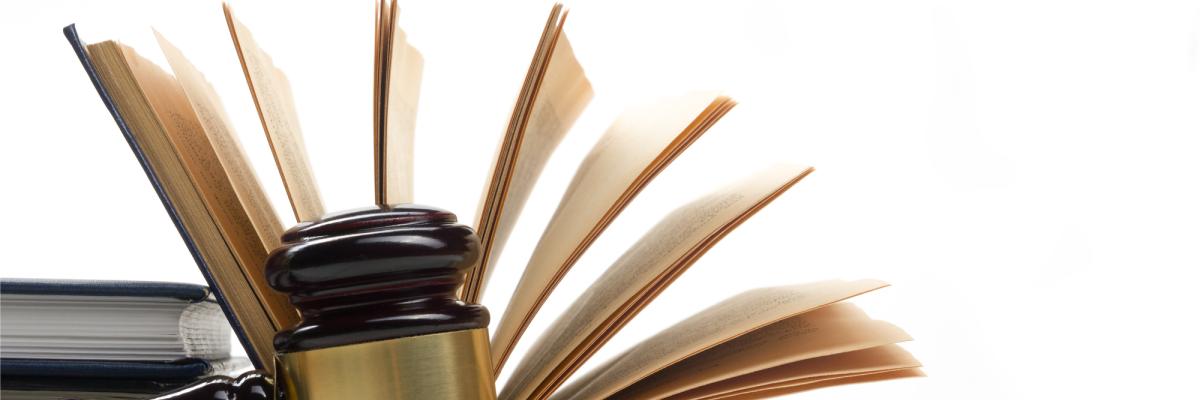 A gavel sitting in front of an open book