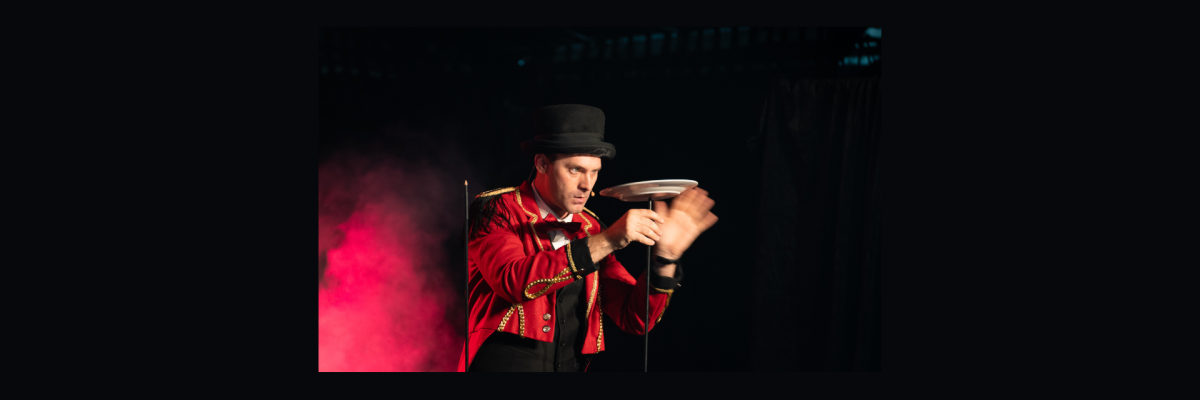 Circus performer focuses intensely on a spinning plate