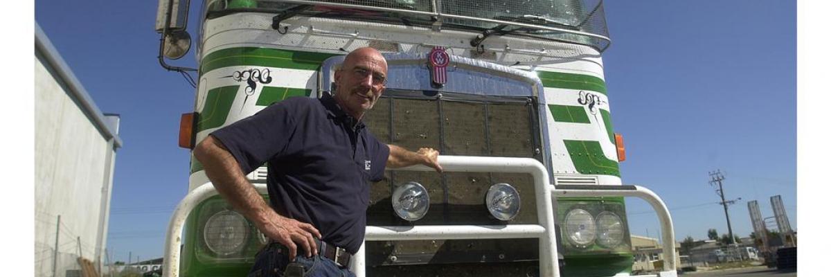 Truck driver standing in front of a truck