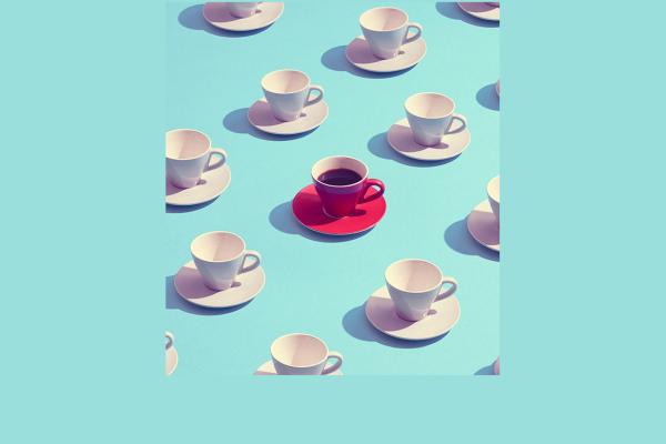 Many white teacups and one red teacup on a blue background