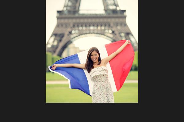 French woman with the french flag in front of the eiffel tower