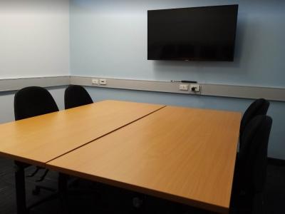 Small room with chairs and a tv screen