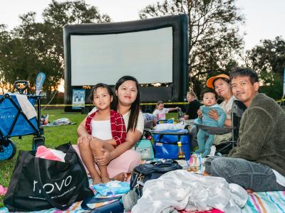 Image of family sitting in front of an outdoor screen