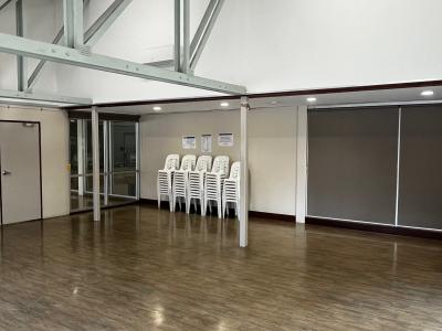 Meeting Room with vinyl flooring and stacked white plastic chairs