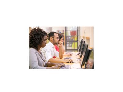 Man and two women using desktop computers