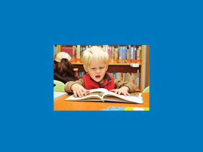 Boy reading a book in a library