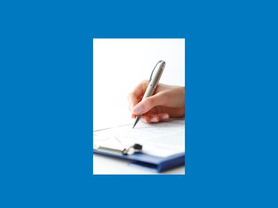 Hand holding a pen filling in a form on a clipboard