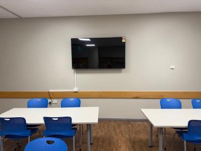 Desks with chairs and a TV mounted to the wall