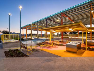 Barbecue and picnic area with shelter in foreground, with huge roof in background