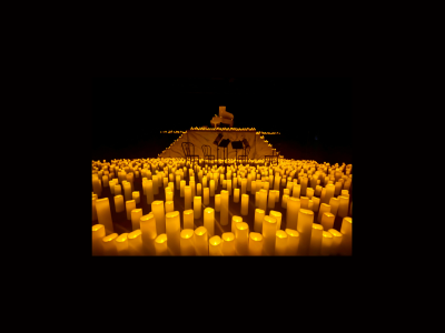 Many LED candles, and a large piano on a stage in the background