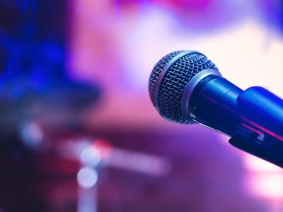 A microphone up close, against a purple and blue blurred background