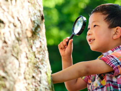 Boy looking through magnifying glass