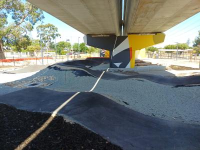 Pump track under shade of overhead rail line