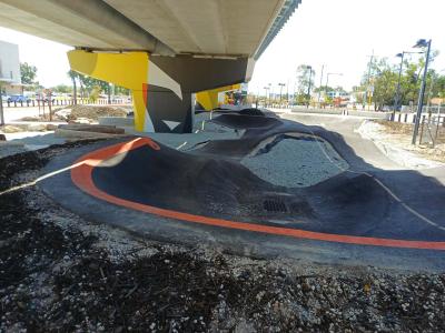 Pump track under shade of overhead rail line