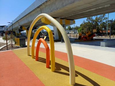 Rainbow sculpture with raised railway line in background