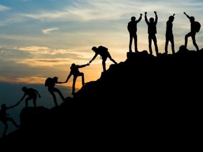 Group of men on peak mountain climbing helping team work 