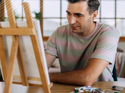 A person painting on a small canvas