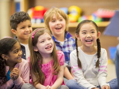 A group of diverse children sitting on the floor listening to a story